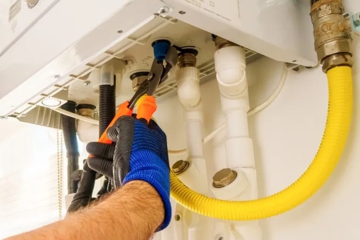 Plumber soldering copper water pipes in a Rochester home